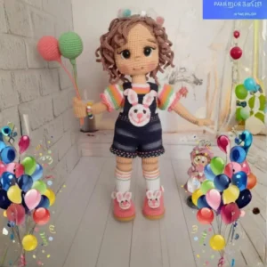 Boneca em amigurumi com cabelos cacheados, jardineira, balões e acessórios de coelhinho