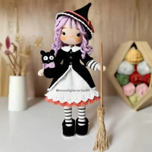 Boneca bruxinha Agatha em amigurumi com cabelo lilás, chapéu preto, gatinho e vassoura