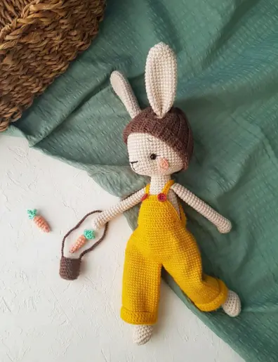 Boneca coelhinha em amigurumi com orelhas compridas e jardineira amarela