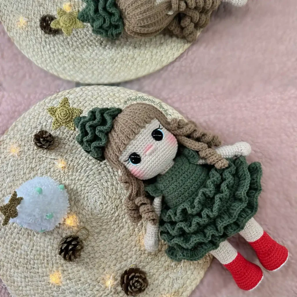 Boneca natalina em amigurumi com vestido verde de babados, cabelos cacheados e sapatos vermelhos