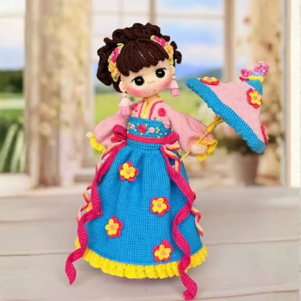 Boneca oriental em amigurumi com vestido azul e rosa, flores coloridas e sombrinha rosa
