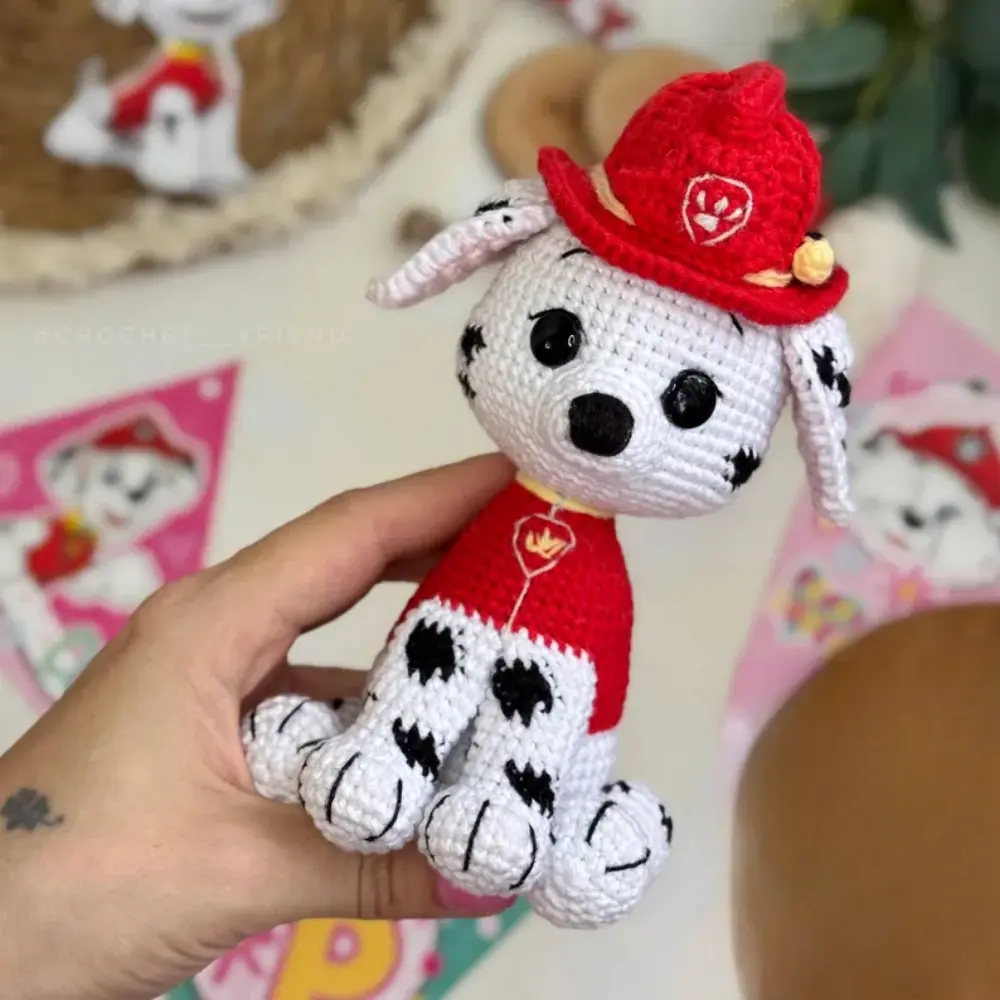 Cachorrinho bombeiro em amigurumi branco com manchas pretas, roupa e capacete vermelhos