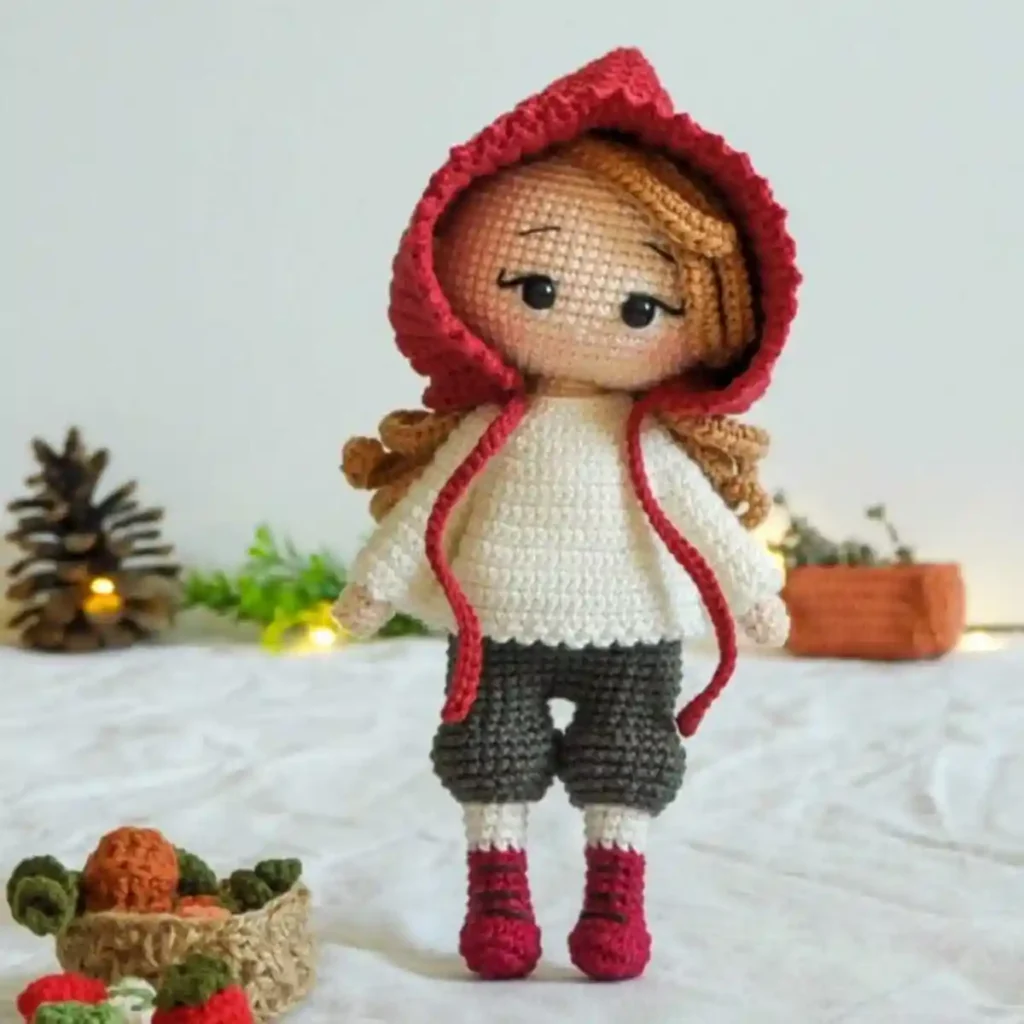 Boneca Chapeuzinho Vermelho em amigurumi com capuz vermelho, cabelo cacheado e botinhas