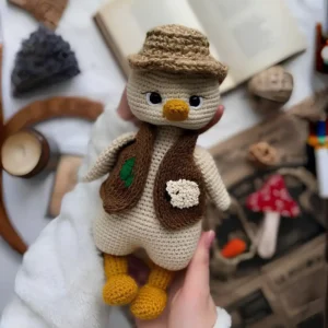Corujinha bege em amigurumi com chapéu marrom, colete decorado e pés mostarda