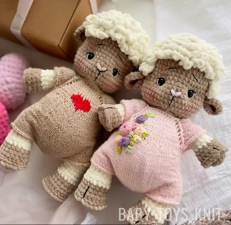 Duas ovelhinhas em amigurumi com macacões bege e rosa e lã branca fofinha