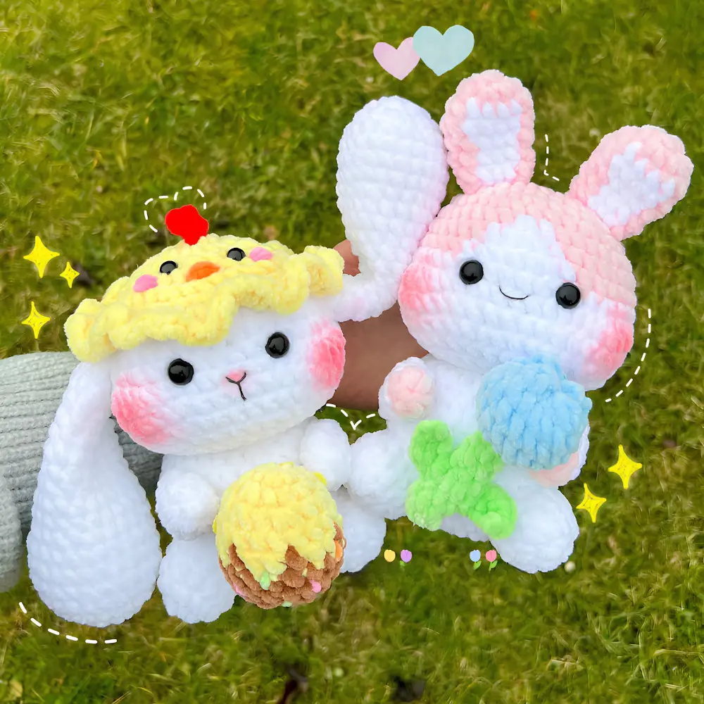 Dois coelhinhos de Páscoa em amigurumi branco e rosa com gorrinho de pintinho e acessórios coloridos