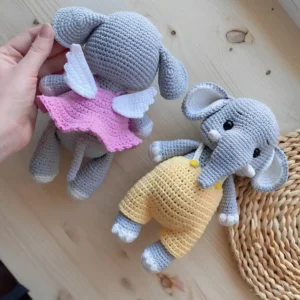 Dois elefantinhos cinza em amigurumi, um com vestido rosa e asas brancas e outro com jardineira amarela