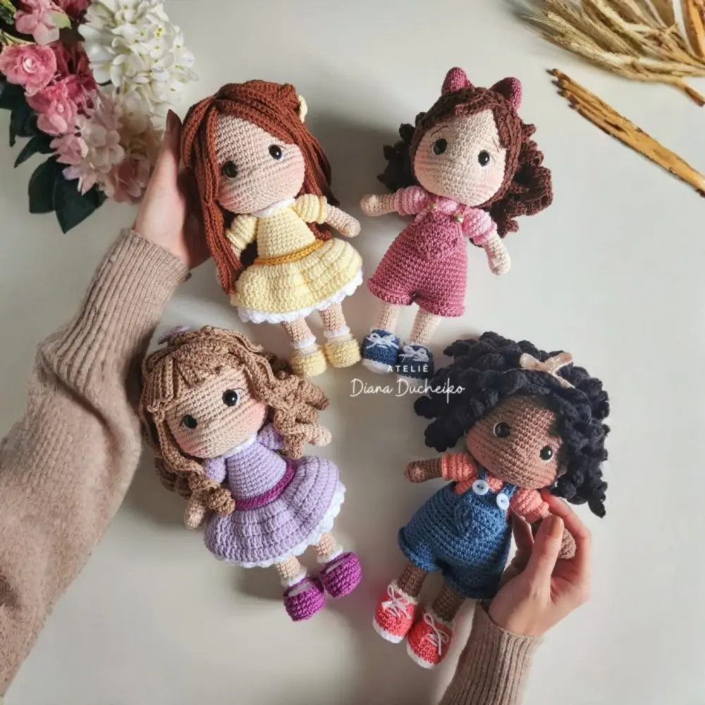 Kit com quatro bonecas em amigurumi com diferentes cabelos, roupas e tons de pele