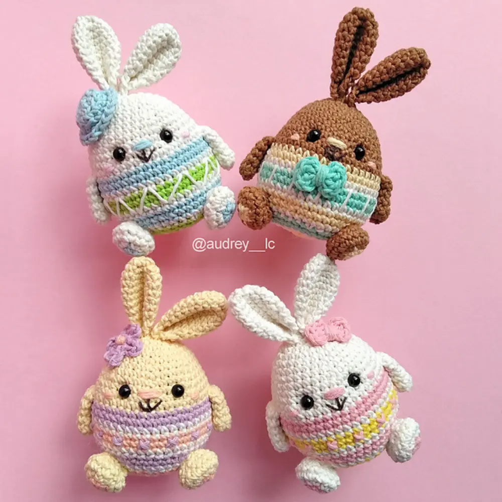 Quatro coelhinhos de Páscoa em amigurumi nas cores branco, marrom e amarelo com detalhes pastel